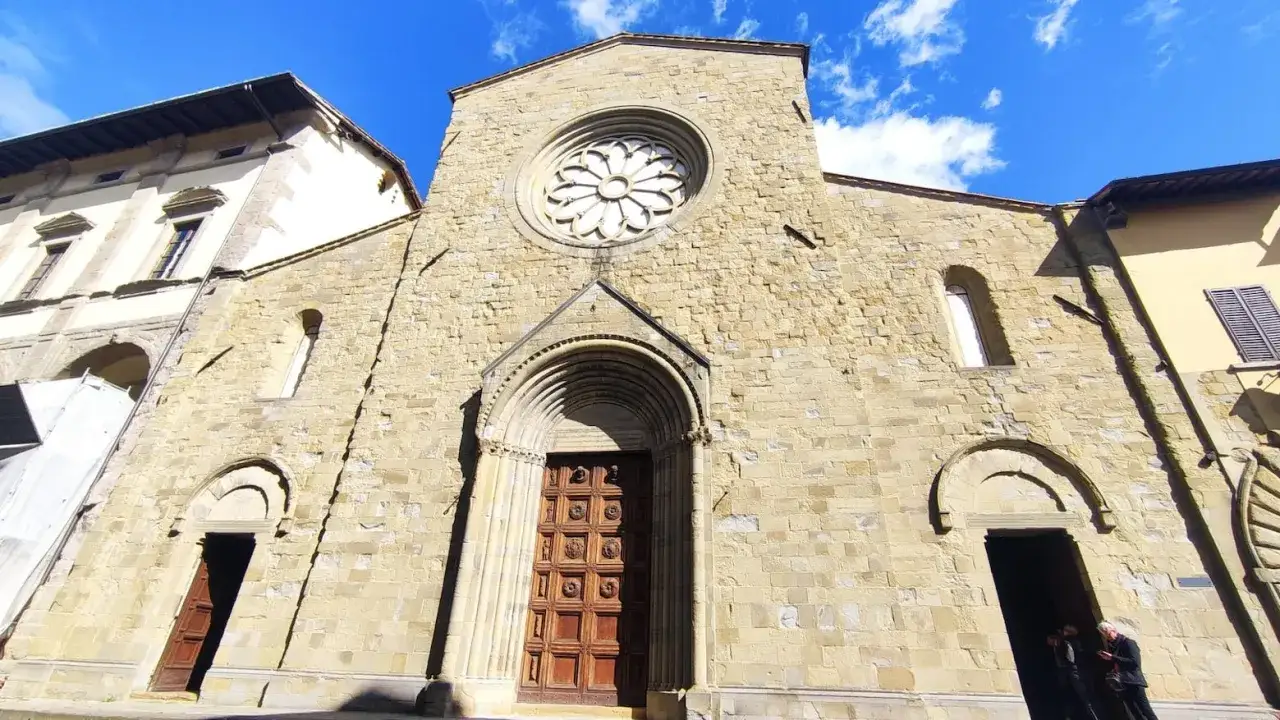 Facciata romanica del San Sepolcro, con rosone e portale in pietra.