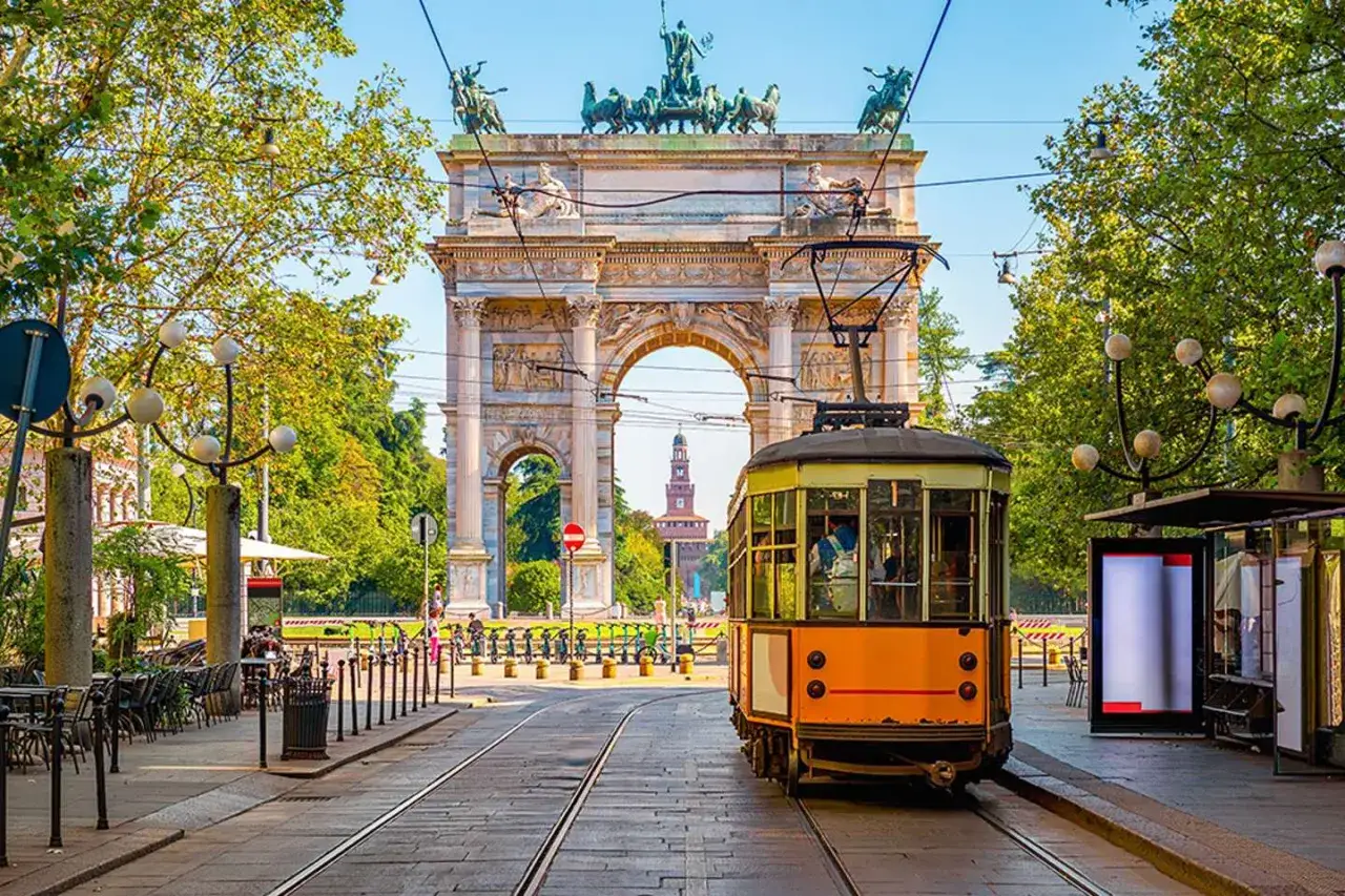 Tram giallo a Milano, con l'Arco della Pace sullo sfondo. Ideale per scoprire la citt&agrave; con visite guidate gratuite a Milano.