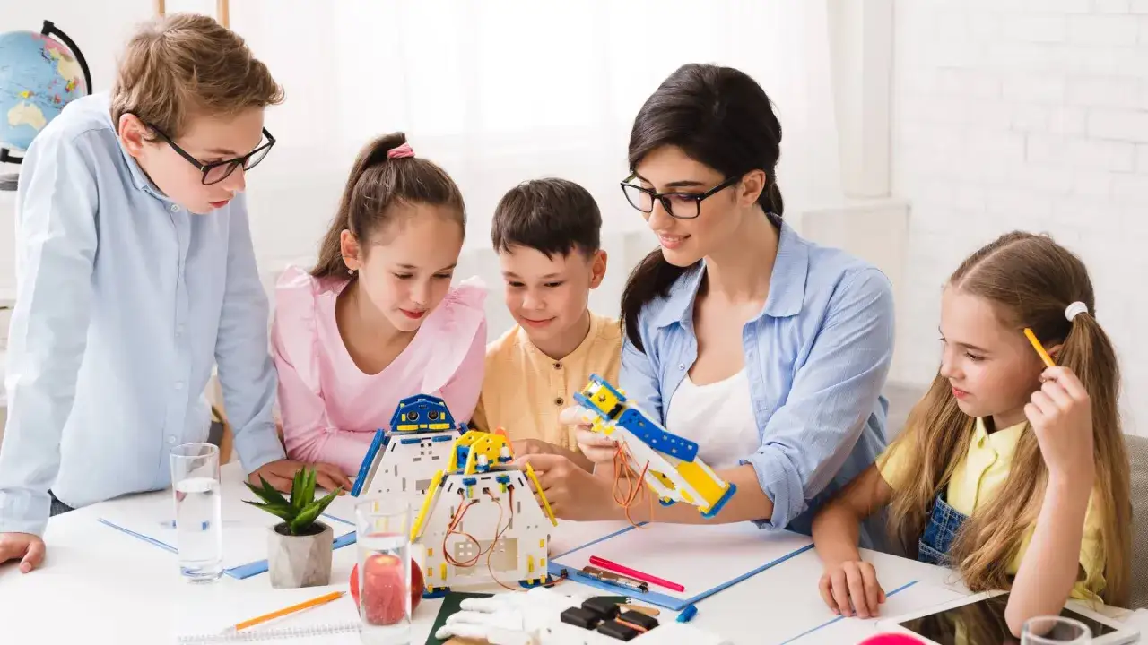 Bambini e insegnante costruiscono robot, un'attività che mostra il significato di itp scuola: apprendimento pratico e innovazione.