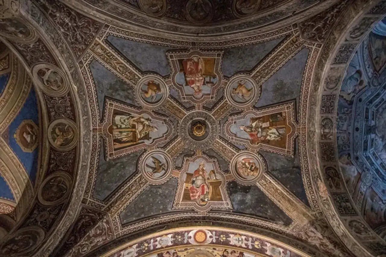 Volta affrescata di San Michele a Pavia, con scene bibliche e figure angeliche che adornano le volte a crociera, un capolavoro di arte religiosa.